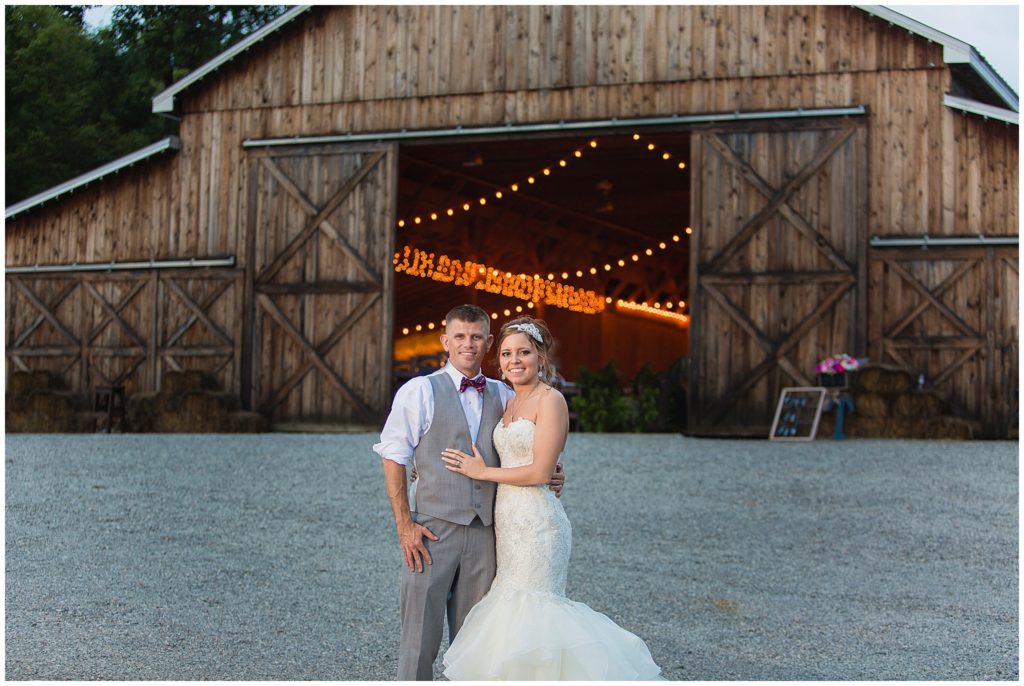beautiful married couple in front of barn venue