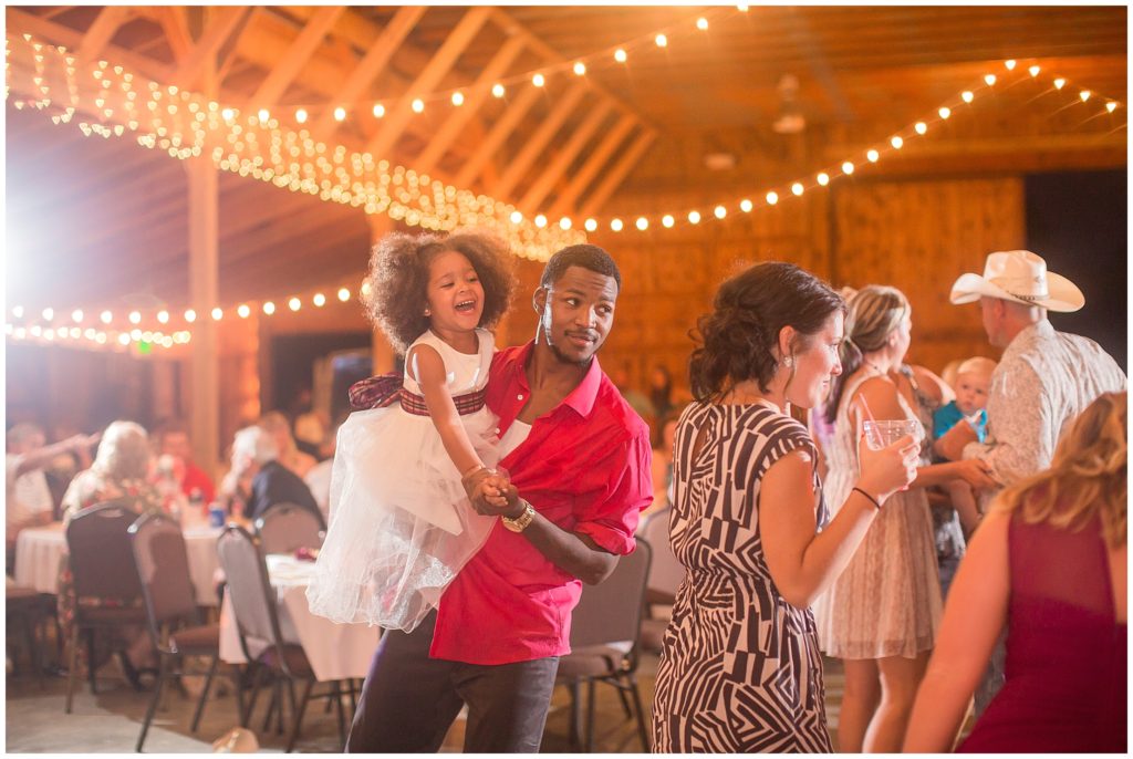 adorable girl dancing at a reception in barn